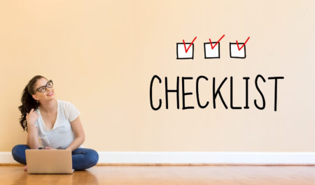 girl on floor looking up at check list